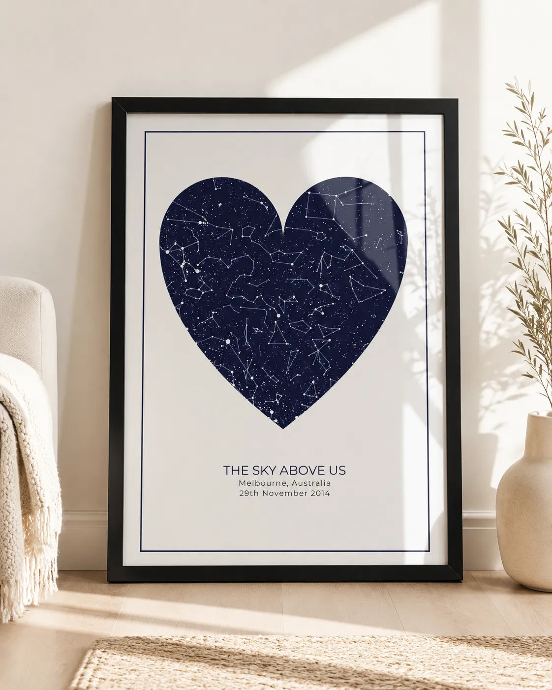 Framed star map print styled on a wall